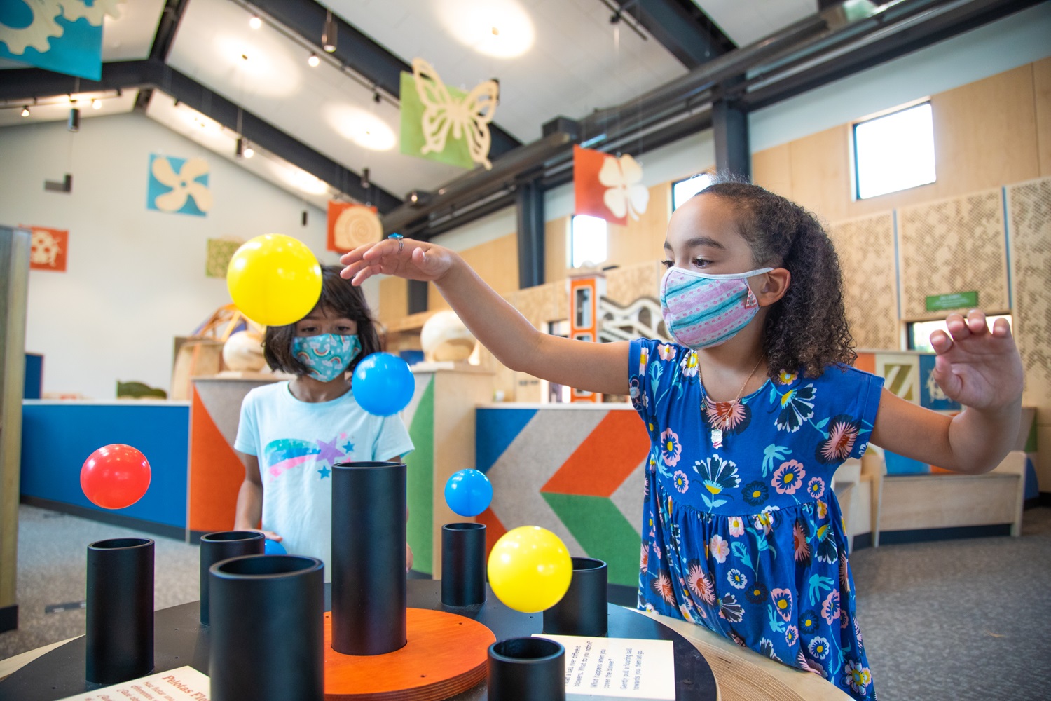 Two children learn about gravity by using the Curious by Nature exhibit