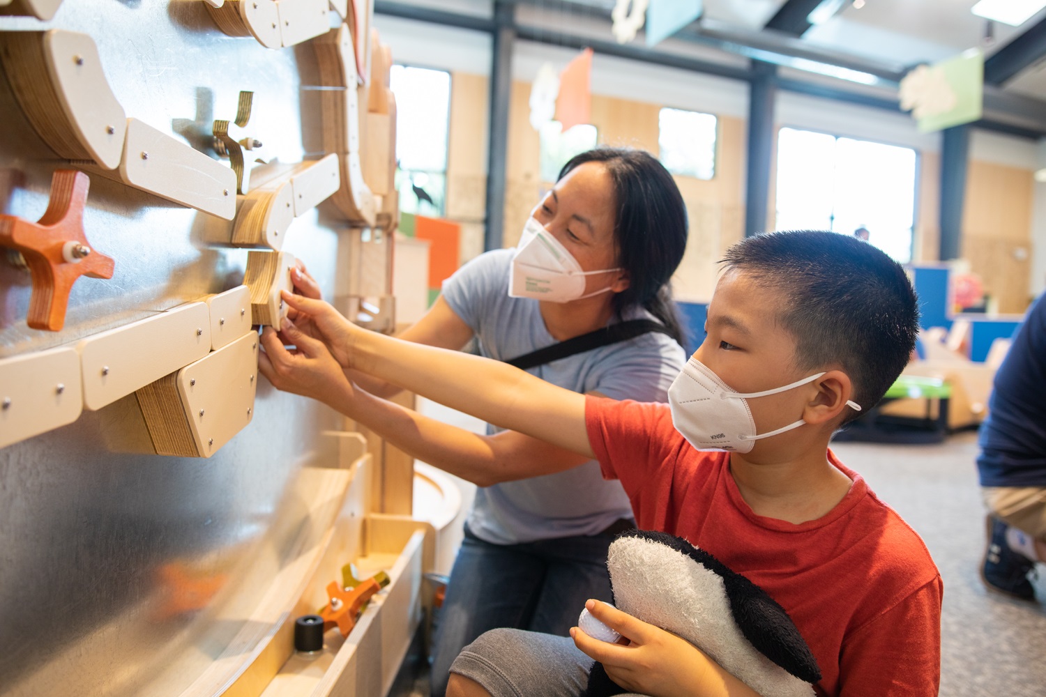 A child and their parent interact with the Curious by Nature exhibit