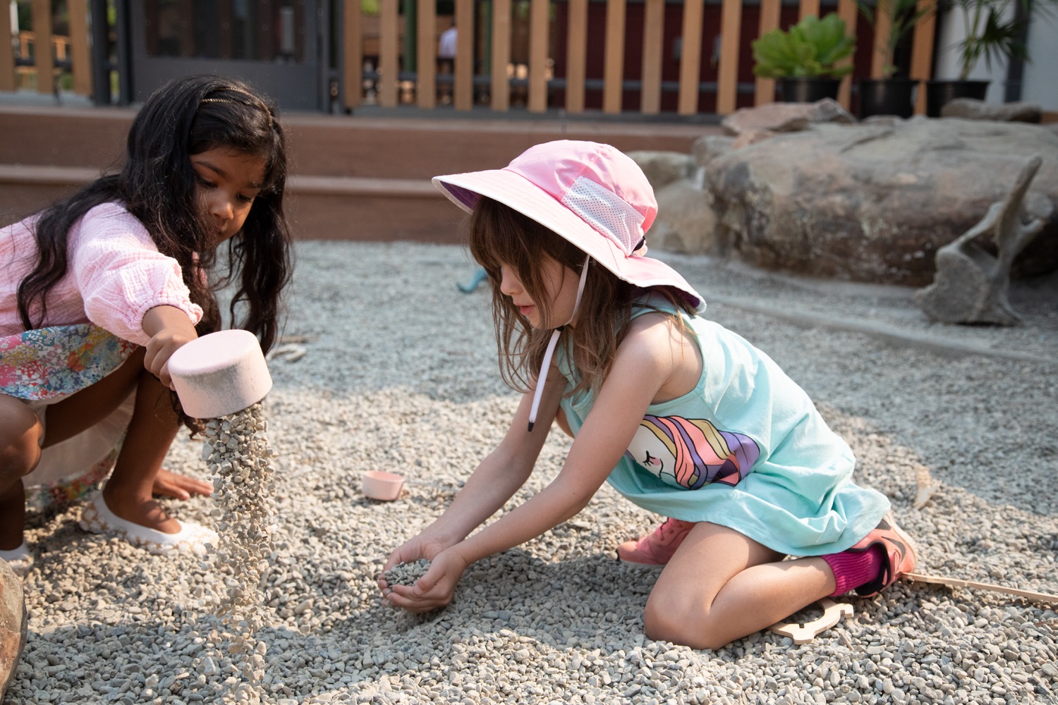 Two kids dig through gravel in the Dawn Redwood Courtyard