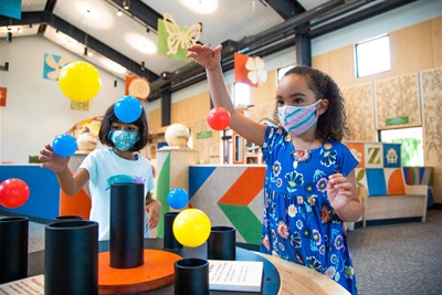 Two girls play in the Junior Museum & Zoo exhibit hall